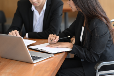 Woman in Wheelchair Working with Colleague